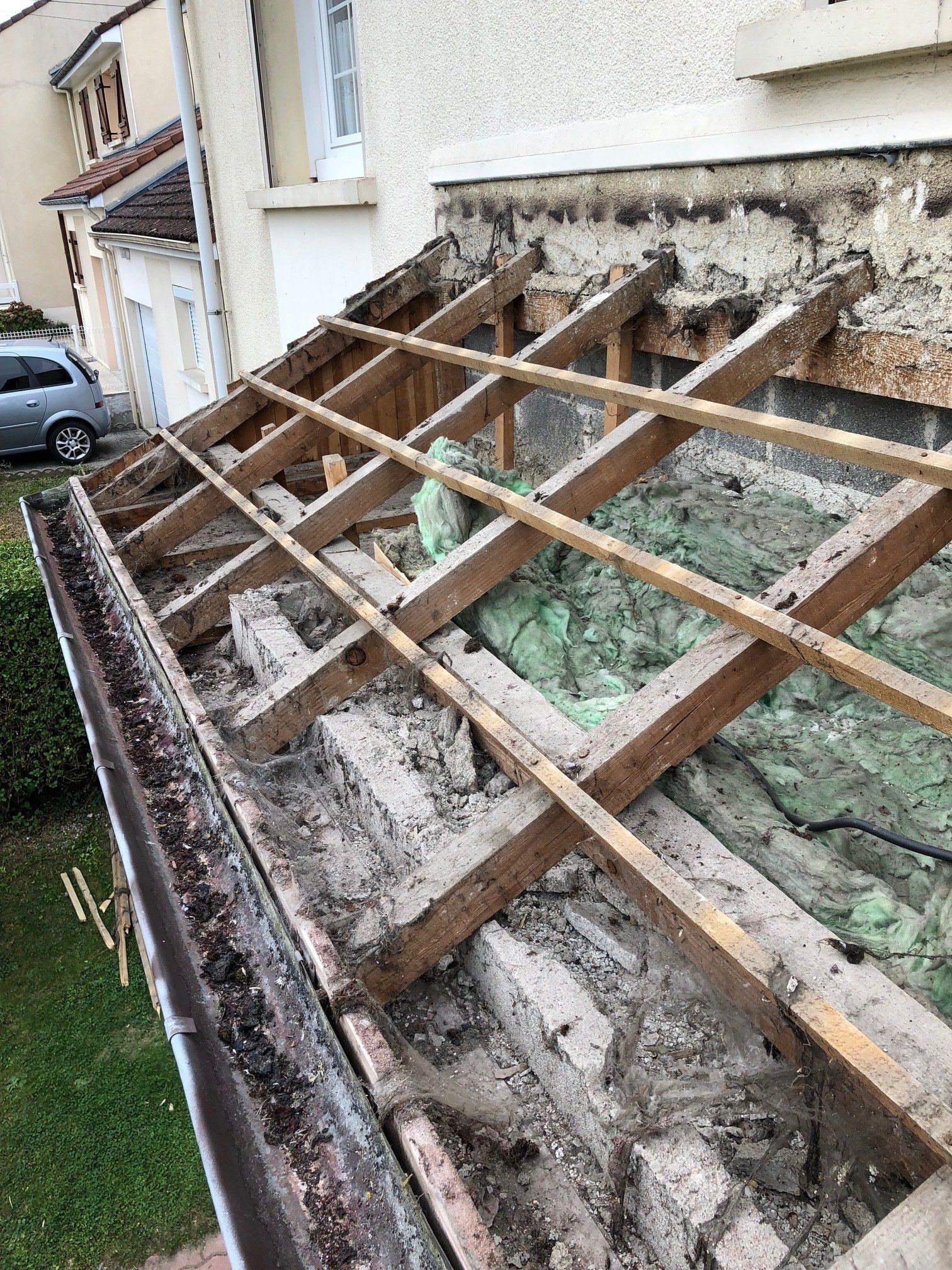 Une charpente en bois est en train d'être retirée d'une maison.